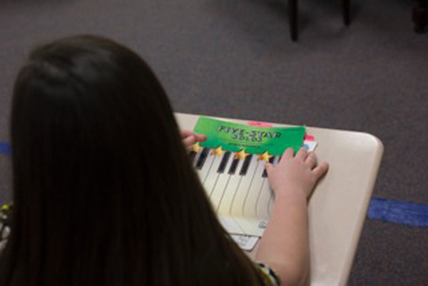 over the schoulder shot of piano book on a students desk